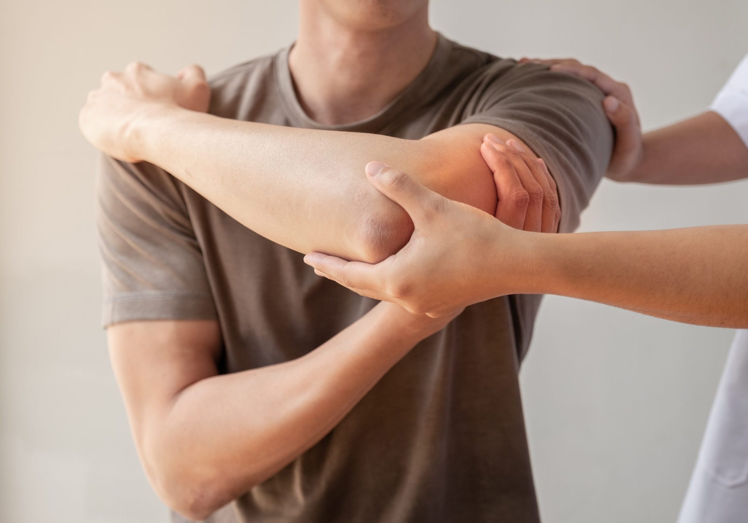 Female physiotherapists provide assistance to male patients with elbow injuries examine patients in rehabilitation centers. Physiotherapy concepts.